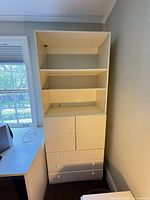 Full view closed: tall white cabinet with shelves, doors, drawers