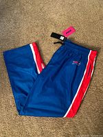 Full view of pants front side showing logo and stripe details