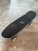 Top view showing black grip tape, LY logo, wheel colour and deck shape