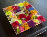 Top view of clear acrylic tray with colorful embedded flowers