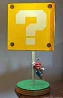 Front view of question block lamp showing shade, base and Mario pull chain
