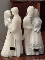 Front view of both wrapped wedding couple candles showing Allure nameplates and silver accents
