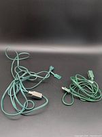 Two green indoor extension cords coiled on black background