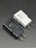 Black and white Samsung USB wall chargers side by side showing form and plugs
