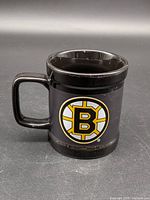 Front view of black mug displaying Boston Bruins logo