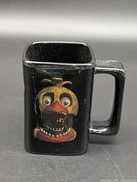 Front view showing Chica graphic on black square mug