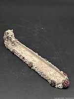 Full view of resin skeletal unicorn incense holder showing tray and decorative elements