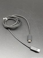 Black HDMI cable coiled with two Type-A male connectors visible