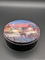 Closed tin showing winter scene graphic on lid
