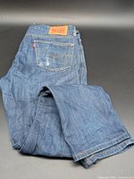 Full view of folded jeans showing color and overall condition