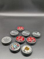 Group of nine branded hockey pucks