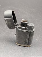 Lighter with cap open showing jet nozzle and wear