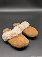 Oblique view of both sandals showing suede uppers and faux fur trim