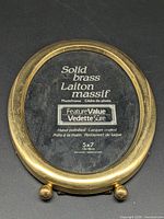 Front view showing brass frame, glass, insert card with branding and size