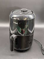 Front view of black T-fal air fryer showing body, handle and power cord