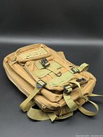 Front view of tan tactical backpack showing compartments, straps and MOLLE webbing