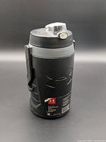 Full view of bottle showing handle, lid, and overall condition