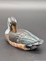 Left front view of wooden duck decoy illustrating head tilt, painted feather detail and glass eye