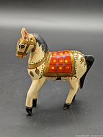 Left side view of painted wooden horse figurine