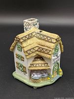 Front left view showing thatched roof, chimney opening, plum basket