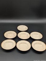 All seven matching stoneware bowls displayed face up