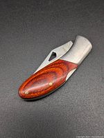 Knife folded, wood inlay handle and stainless frame visible