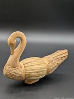 Left side view showing carved head, reed body, driftwood tail