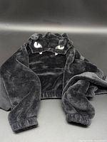 Front view showing cropped body, hood with bat eyes and fangs