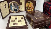 Two open boxes showing plates and certificates plus three closed presentation boxes