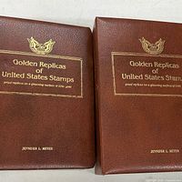 Front covers of both brown binders with gold foil titles and personalized name
