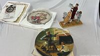 Boxed plate with foam insert beside unwrapped plate and figurine