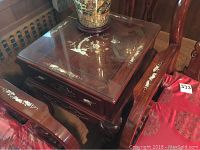 Top view of the square wooden side table showing clear glass top and detailed mother of pearl inlay with floral and bird motifs.