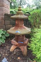 Full front view showing entire two-tier pagoda lantern in garden setting