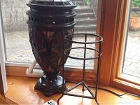 Lamp and plant stand on wooden ledge by window