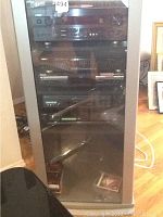 Stereo cabinet with glass door containing Yamaha receiver, Teac equalizer, Phillips CD player, Sony VCR and Sony DVD player.