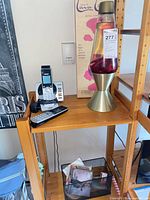 Shelf with VTech phone system, Lava Lite lamp and box, basket with CDs