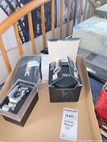 Tray holding Roots watch in open case, repair kit pouch, Citizen box components, MaxSold tag