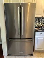 Front view of closed KitchenAid stainless steel French door refrigerator