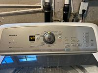 Control panel with digital display, buttons, and glass lid