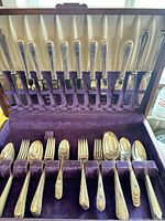 Open chest showing knives in lid and first tier of forks and spoons