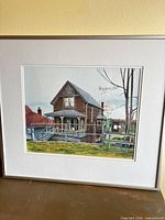 Front view of framed watercolor painting showing house subject