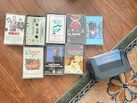 Eight commercial cassette albums and one empty plastic cassette keeper