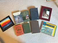 Group shot of all ten hardcover books laid out on carpet