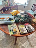 Lot overview showing timers in packaging, extension cords, hardware box on table