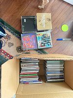 Stack of five highlighted CDs plus open box with additional CDs