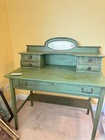Front view of green desk with mirror and drawers