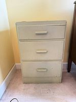 Front view of light green three-drawer dresser showing overall form and color