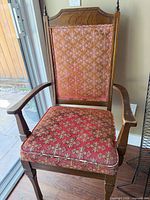 Full view of wooden armchair showing upholstery and frame