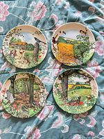 Four decorative plates showing different countryside scenes