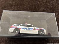 Left side view of white Hamilton Police die-cast wagon in acrylic case